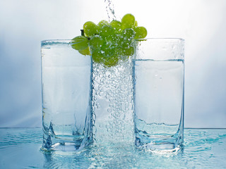 Grapes with two glasses and pouring water making bubbles