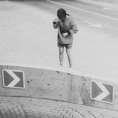 Black and white shot of Young adult female posing for photo on parking