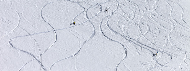Snowboarders and skiers on off-piste slope at sun day