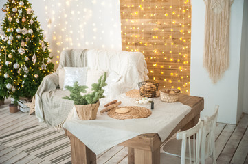 Details of the decorated New Year's interior. Scandinavian living room and kitchen for Christmas. The comfort of homely rustic decor.