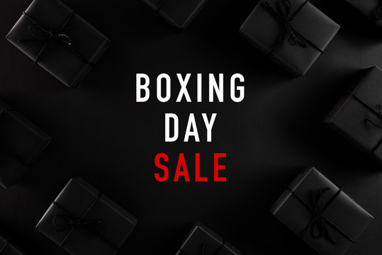 Top view of Boxing day Sale text with black gift box on dark background. Shopping concept boxing day and black Friday composition.