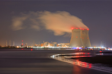 Night scene with view on riverbank with nuclear reactor Doel, Port of Antwerp, Belgium.