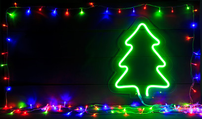 The beautiful christmas background with a lot of colorful lights and green neon christmas tree on...