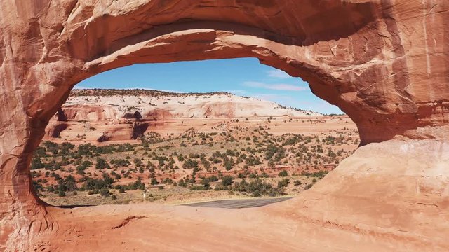 Drone Flies Through The Orange Stone Arch In Massive Rock Formations Aerial