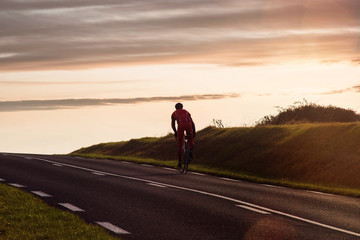 Obraz premium cyclist climbing a slope at sunset