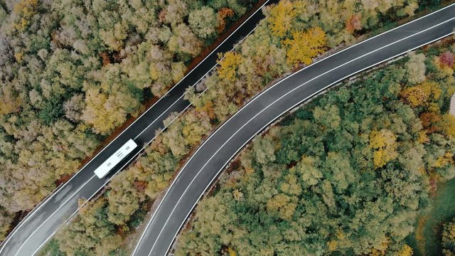 Winding road through a forest, bus taking a sharp turn
