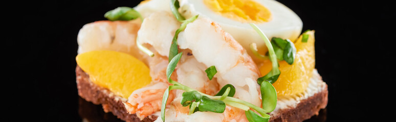 panoramic shot of tasty shrimps on smorrebrod sandwich on black
