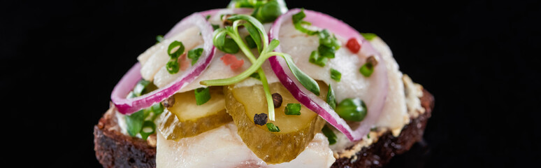panoramic shot of danish smorrebrod sandwich on black