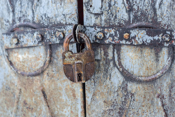 old rusty padlock closes the same old gate