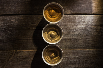 top view of delicious assorted hummus on wooden rustic table