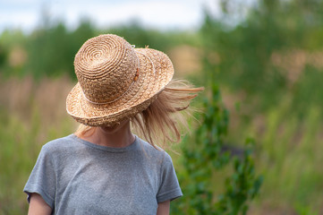 Redhead young girl with straw hat pulled over the eyes