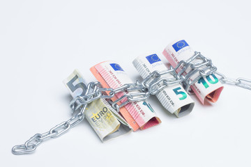 Dinero encadenado; billetes de euros apretujados entre cadenas