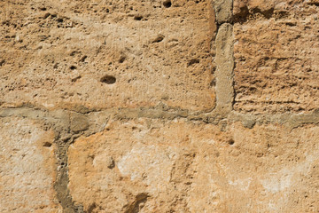 Stones background, blocks background. The wall of light rough old stones, closeup. Seams between blocks. Beautiful background. 