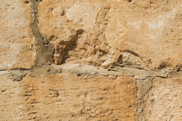 Stones background, blocks background. Stones texture. The wall of light stones, closeup. Seams between blocks. Rough surface. Beautiful background. 