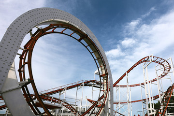 roller coaster track, children carousel on a background of blue sky