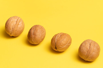 Delicious walnuts on bright yellow background.