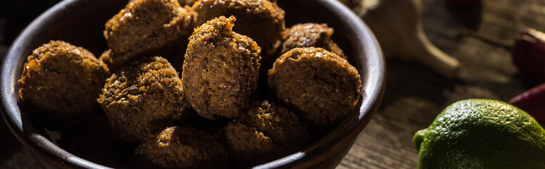 delicious falafel balls near lime on wooden rustic table, panoramic shot