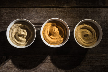 top view of delicious assorted hummus on wooden rustic table