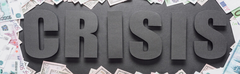 panoramic shot of word crisis in frame of dollar and euro banknotes on black background with shadows