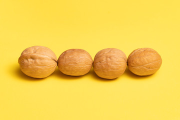 Delicious walnuts on bright yellow background.