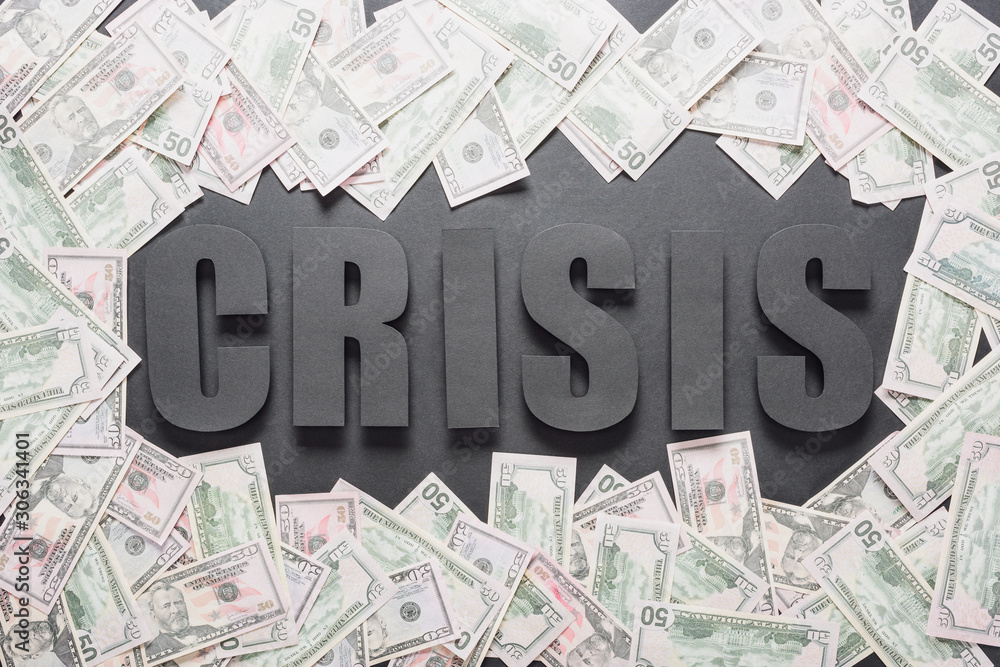 Wall mural top view of word crisis in frame of dollar banknotes on black background with shadows