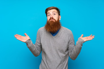 Fototapeta premium Redhead man with long beard over isolated blue background making doubts gesture