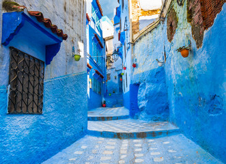 Fototapeta na wymiar Typical street with blue walls in Moroccan city of Chefchaouen