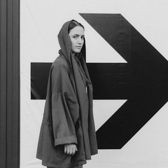 Black and white shot of Young woman in red staying near arrow sign. Success concept