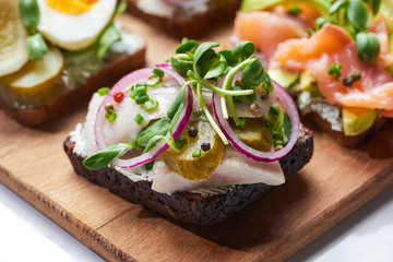 selective focus of of herring fish fillet on tasty danish smorrebrod on white