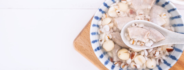 Tasty Four Tonics Herb Flavor Soup, Taiwanese traditional food with herbs, pork intestines on white wooden table, close up, flat lay, top view.