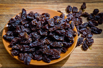 Dried healthy grapes photographed on a wooden surface close-up.