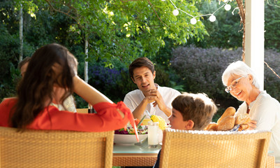 Family eating outside together in summer
