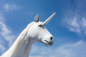 Obraz na płótnie Canvas Unicorn magic animal from fairy tales and symbol of most valued startups for business. Mysterious horse with horn on blue sky background. 3D render illustration