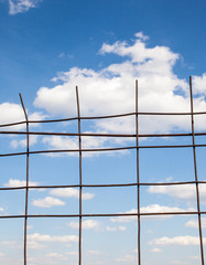 Blue sky behind the metal fence