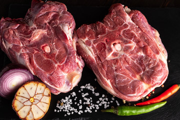 Fresh meat lamb neck on a black stone plate.