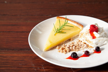 Fresh tasty lemon tart with crumble and whipped cream