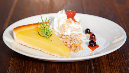 Fresh tasty lemon tart with crumble and whipped cream