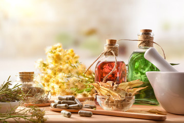 Capsules and essence of natural medicine with medicinal plants front