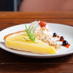 Fresh tasty lemon tart with crumble and whipped cream