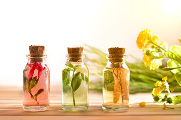 Three jars with plant essence on wooden table background front