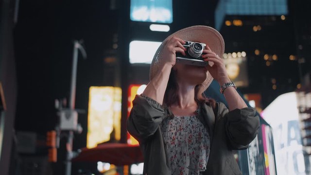 Smiling girl with a retro camera in Times Square, NYC