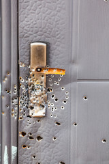 Bullet holes in the metal door