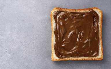 Toast with chocolate butter on gray texture.