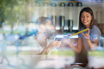 Woman is using measuring tool while man is drinking coffee