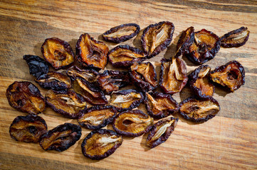 Close-up dried plums, sliced for health, photographed on a wooden surface close-up.
