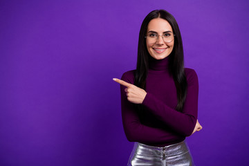 Photo of cheerful positive cute pretty charming girlfriend pointing into empty space isolated...