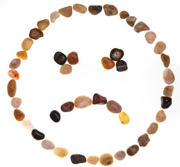 Emoji (emoticon) of sad face handmade with stones (boulders). Isolated on white background. Collection made with stones.