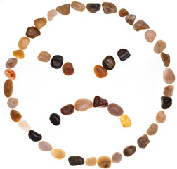 Emoji (emoticon) of very angry face handmade with stones (boulders). Isolated on white background Collection made with stones.