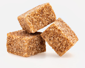 Lumps (cubes) of brown sugar (cane). Caramel brown color. Isolated on white background. Front view.