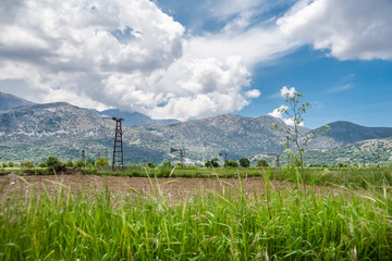 Old windmills on the Lasithi plateau on a background of mountains and clouds